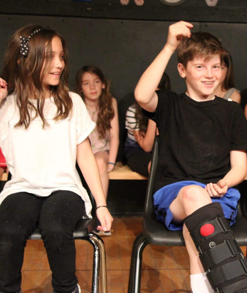 a boy and girl sitting on chairs