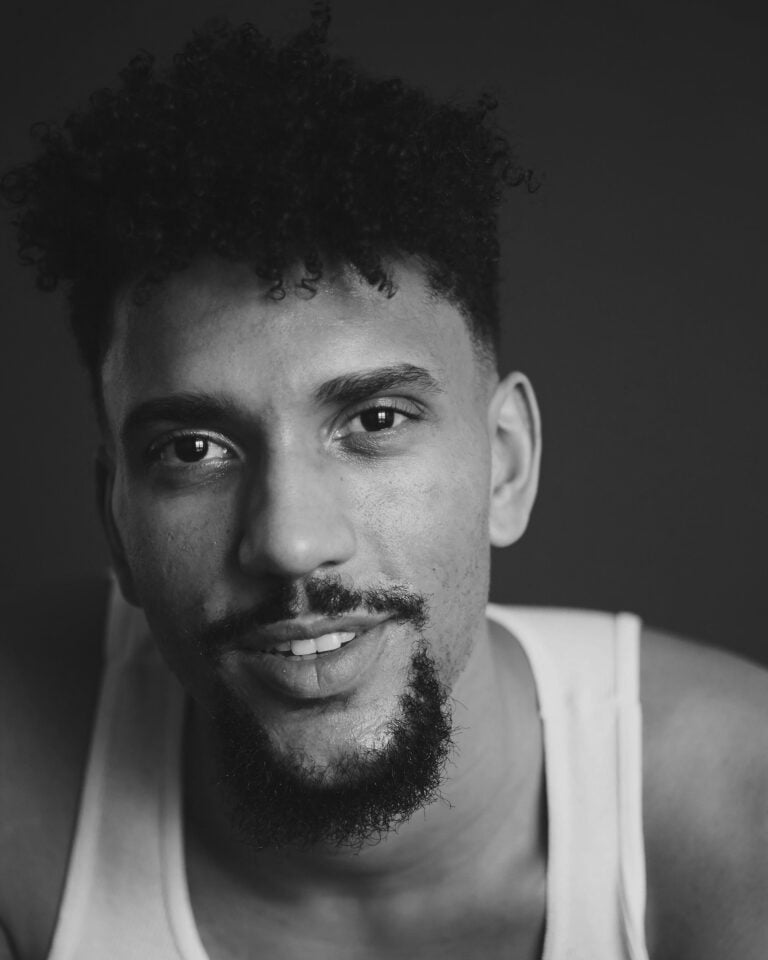 Black and white portrait of Robert Vail with curly hair and a goatee.