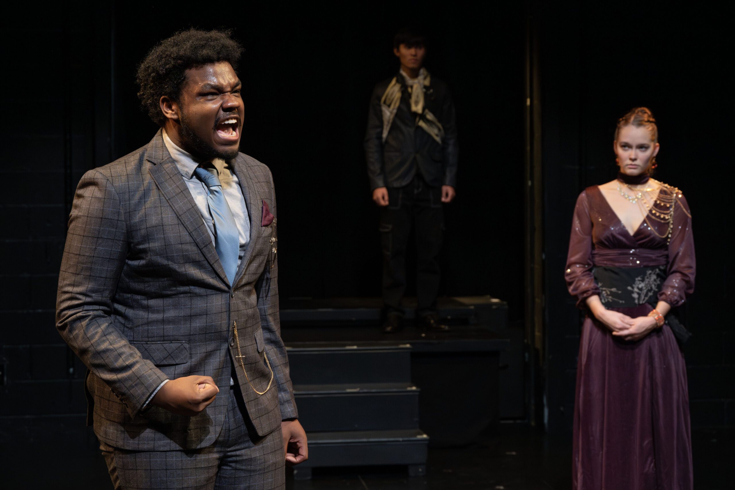 a man in a suit screaming in front of a woman