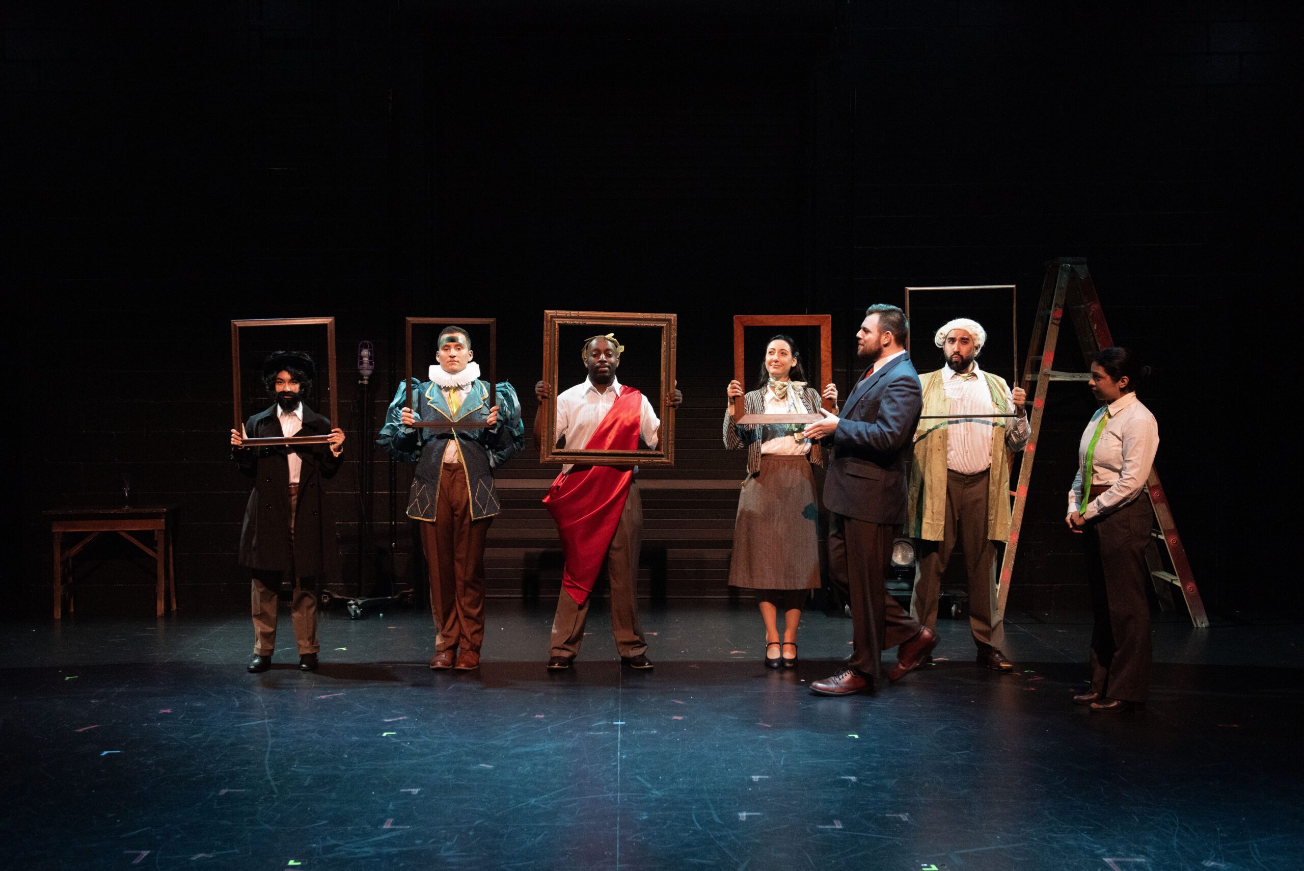 a group of people holding frames on a stage