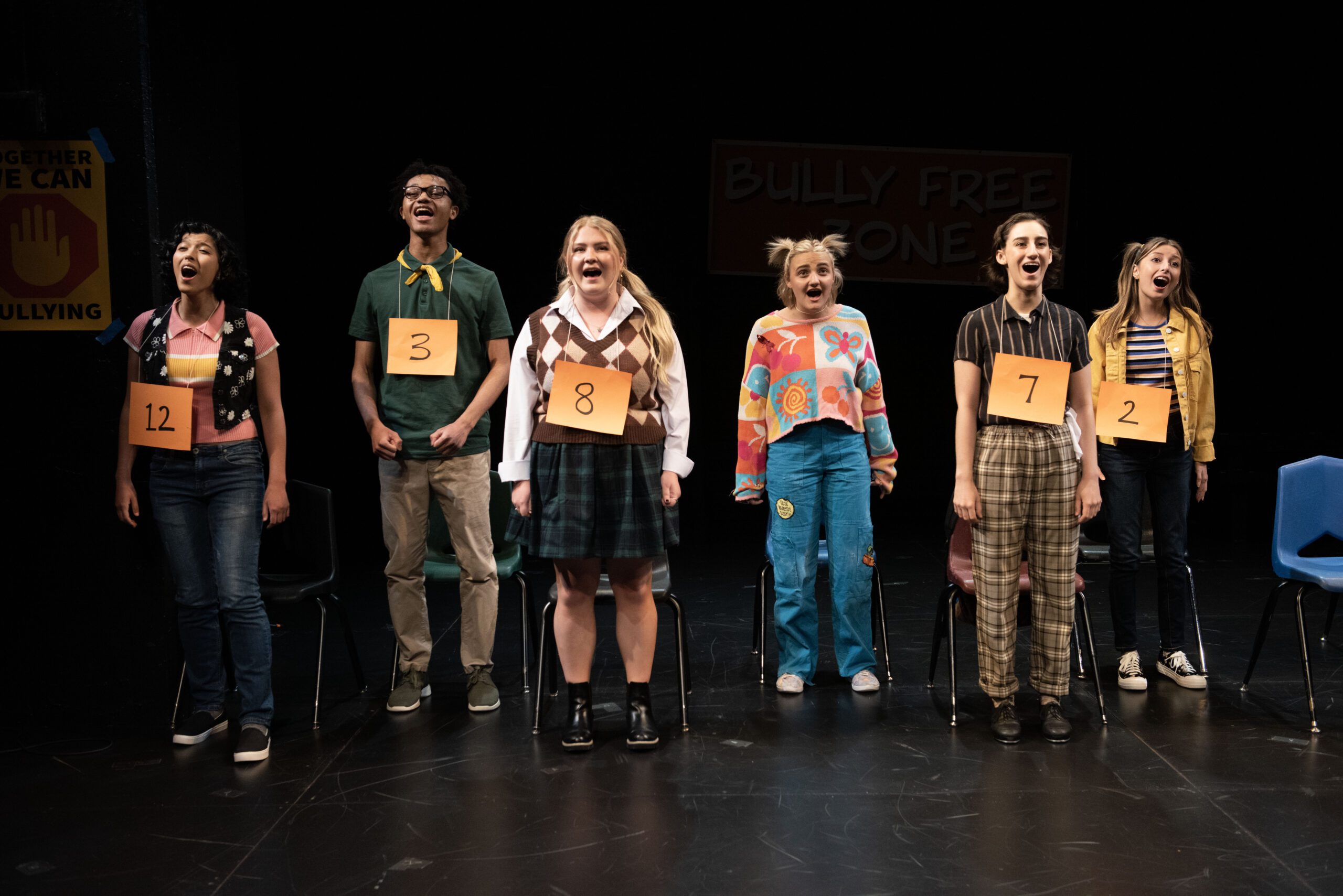 a group of people standing on a stage with signs on them