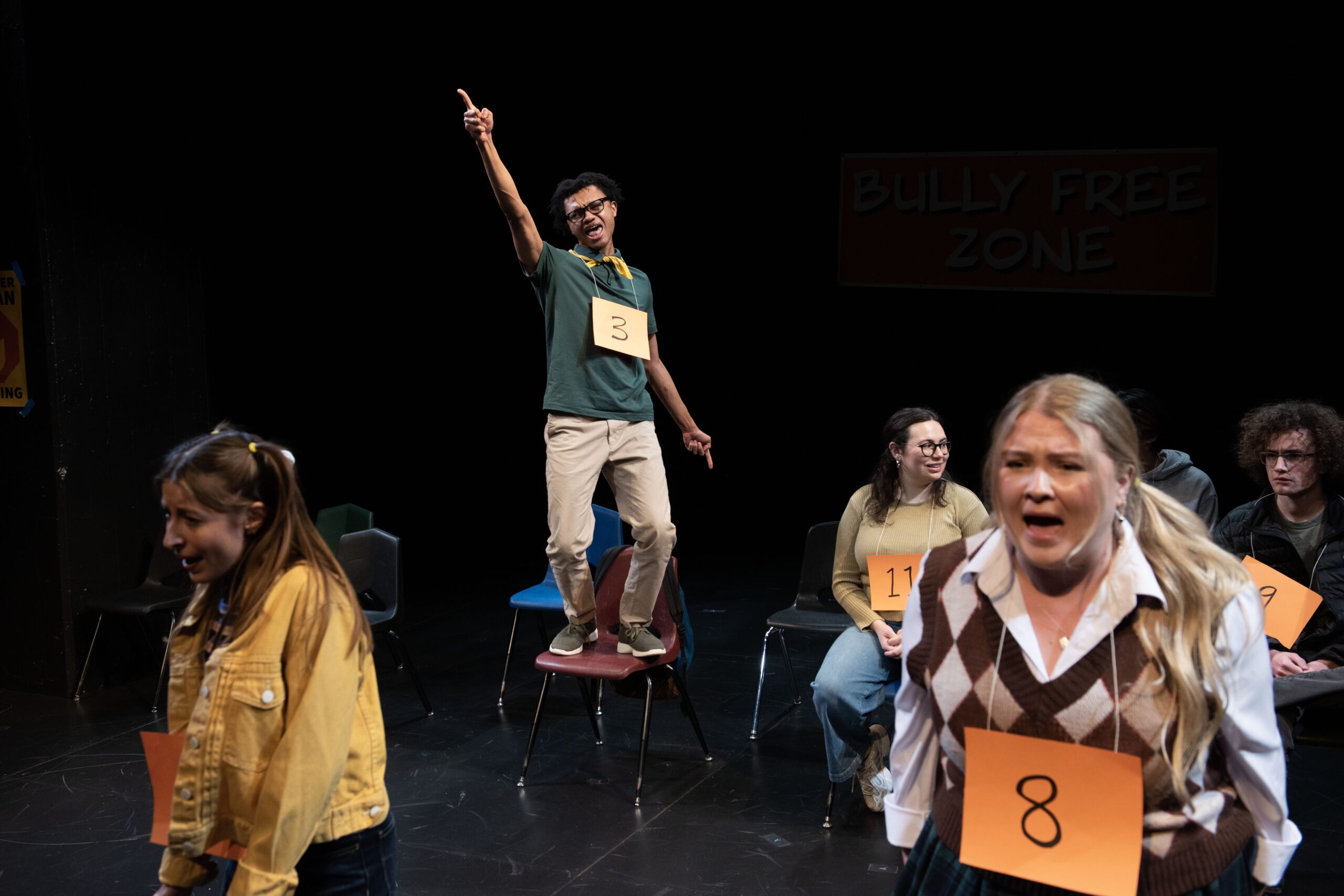 a man standing on a chair with a sign on it
