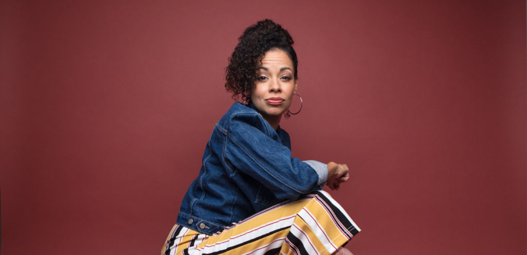 Latina actress in denim jacket and striped pants, embodying the journey back to the stage.