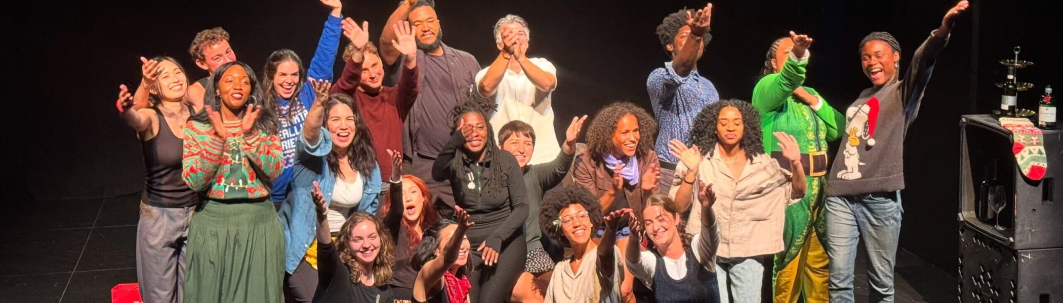 Evening Conservatory students celebrate on stage. Group photo of smiling, diverse performers.