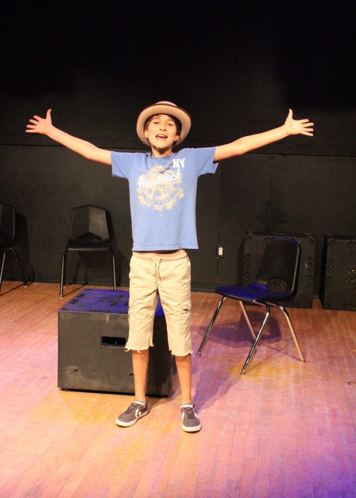 Comedy 101 (11-14) a boy standing on a stage with his arms outstretched