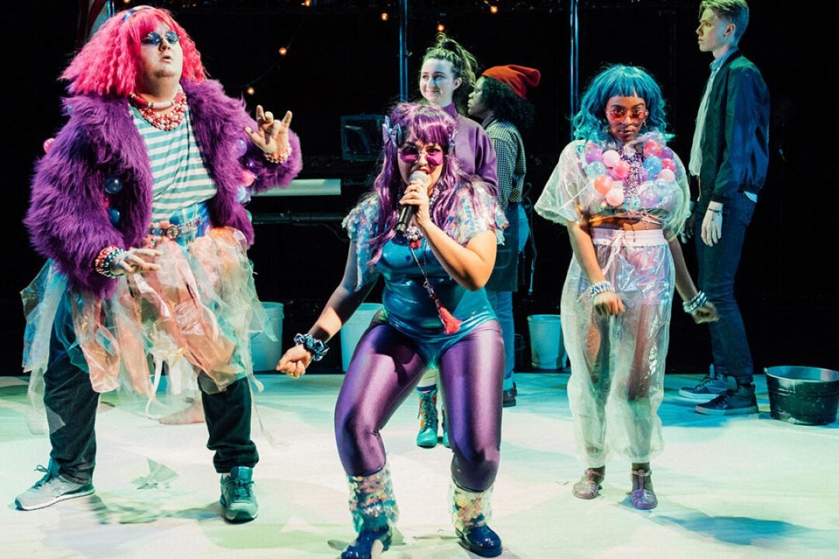 Actors in colorful costumes performing in a stage production.