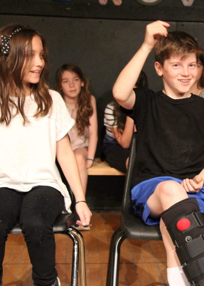 a boy and girl sitting on chairs
