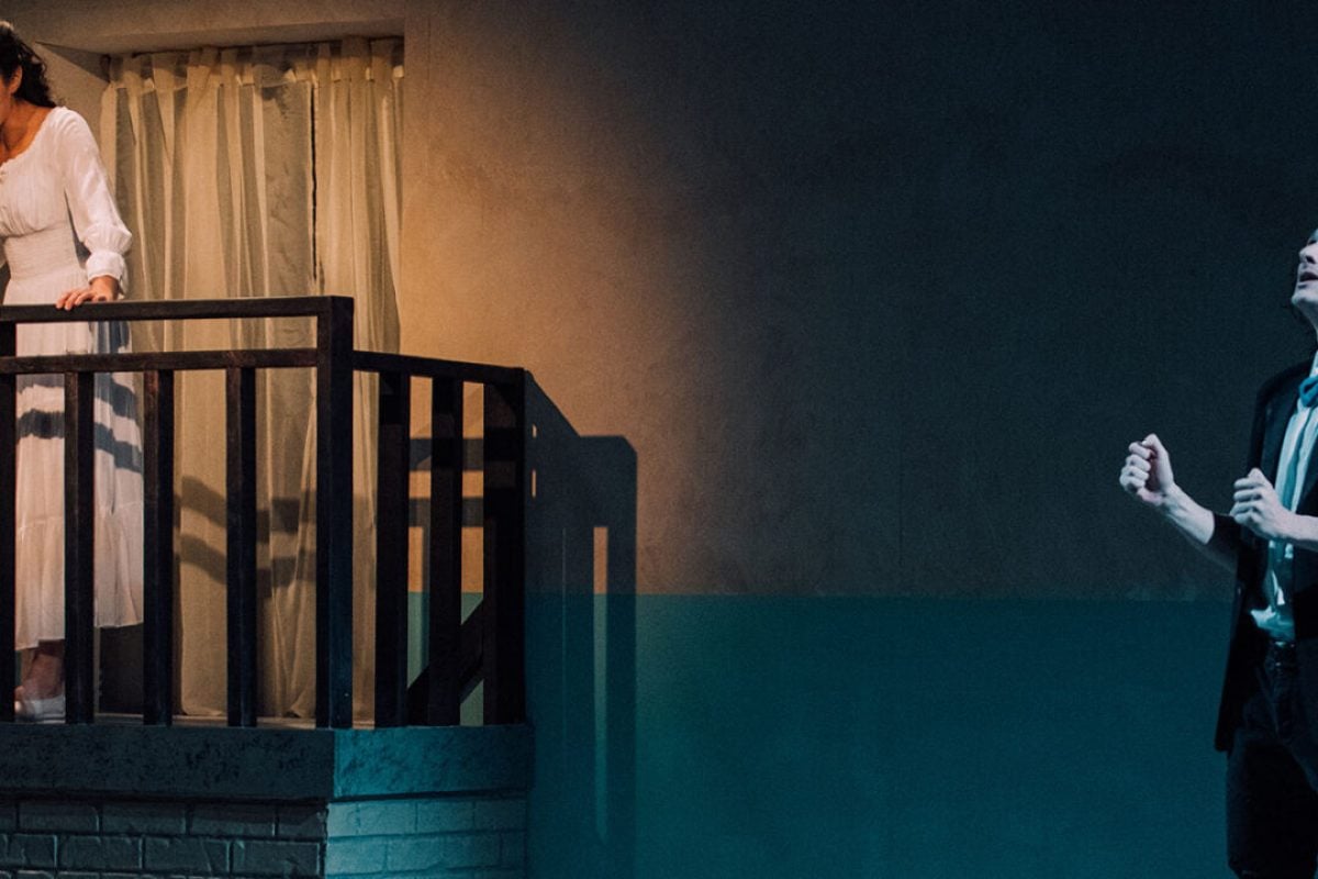 Theater production scene: Woman on balcony, man looking up