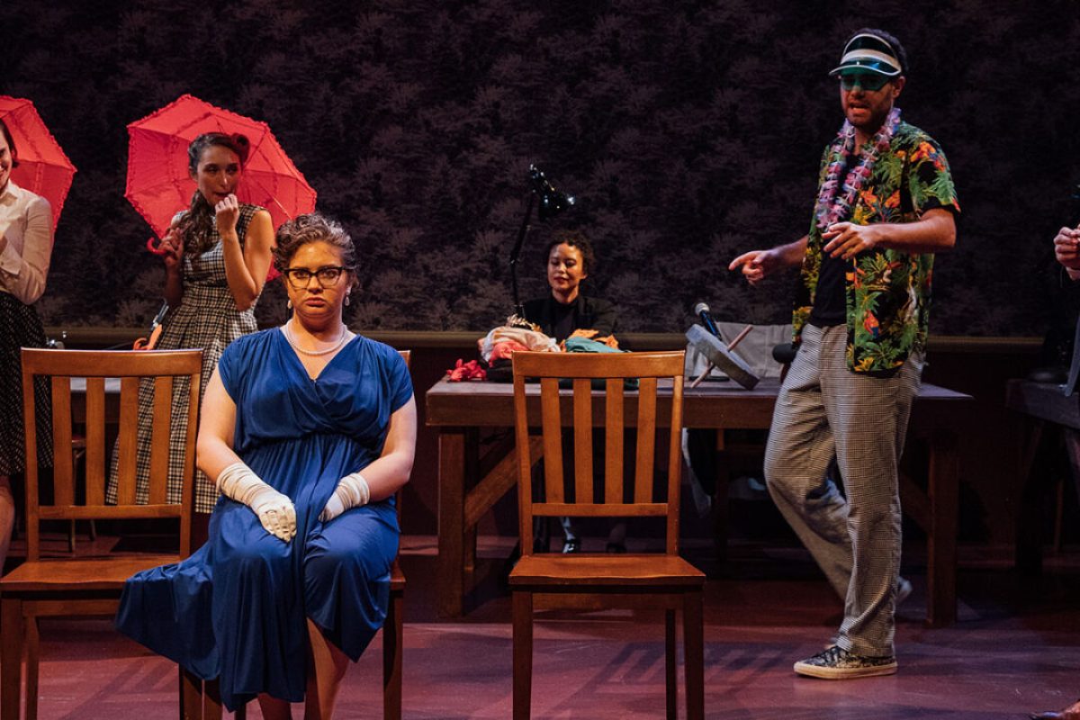 Theater production scene with actors in costume on stage.