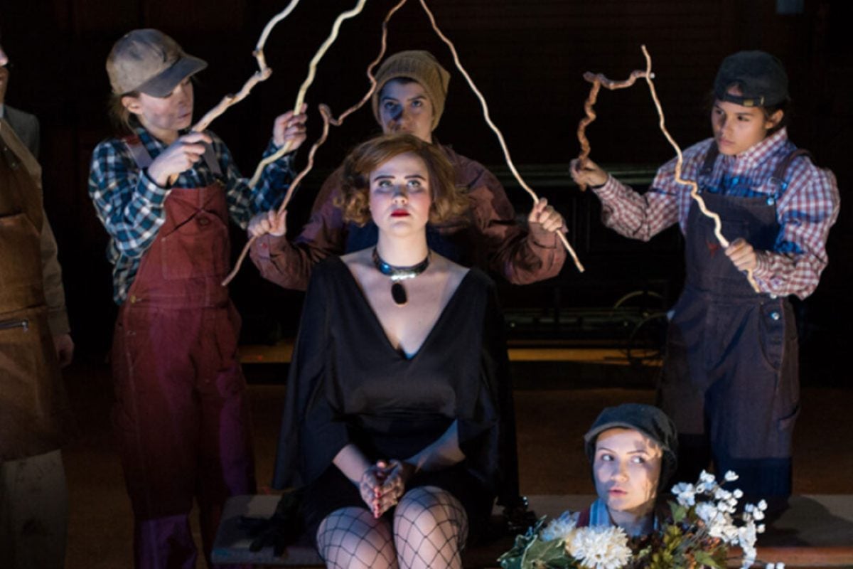 Theater production scene with actors in costume on stage.