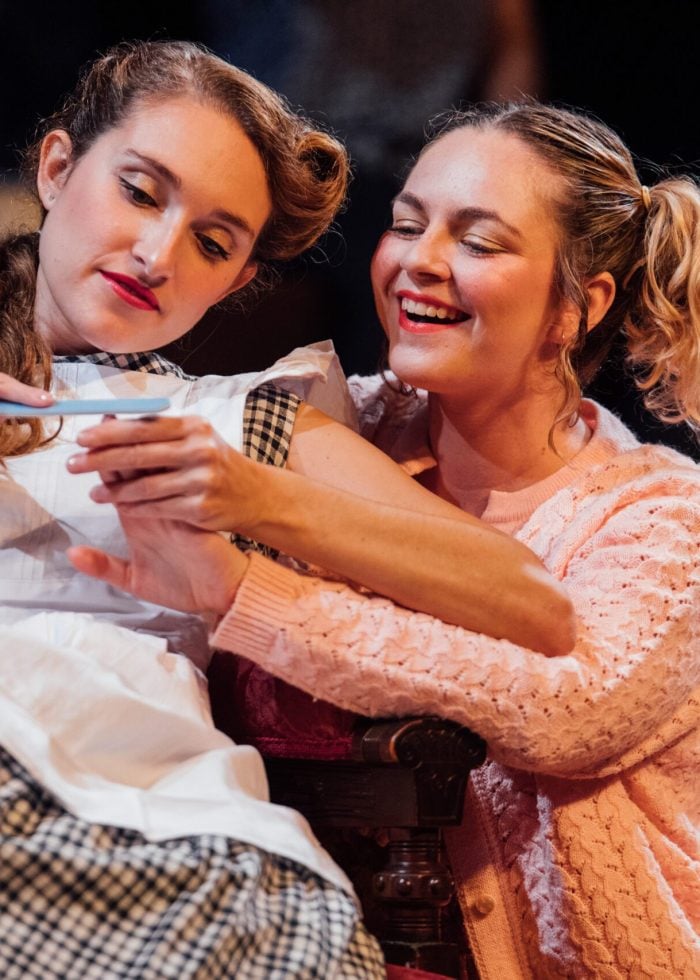 Two women looking at a pregnancy test.