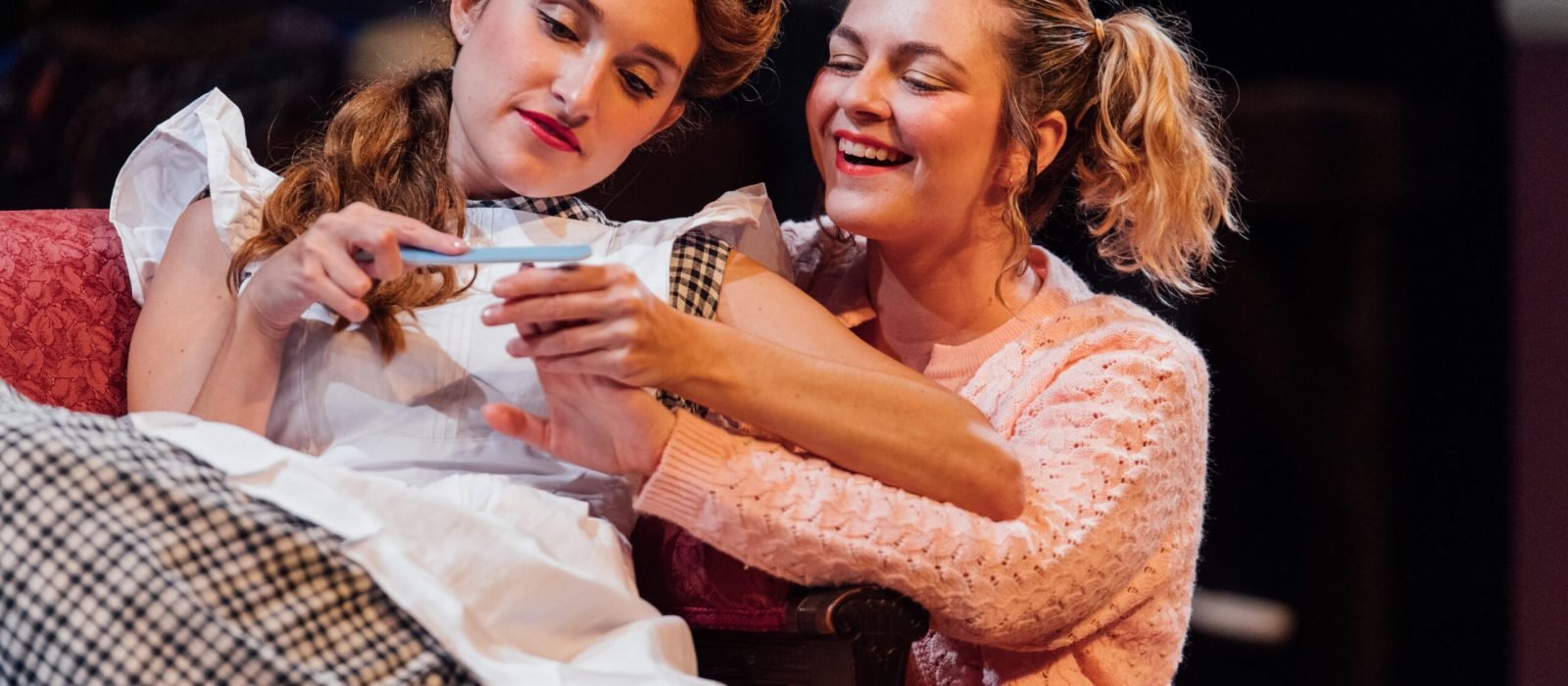 Two women looking at a pregnancy test.