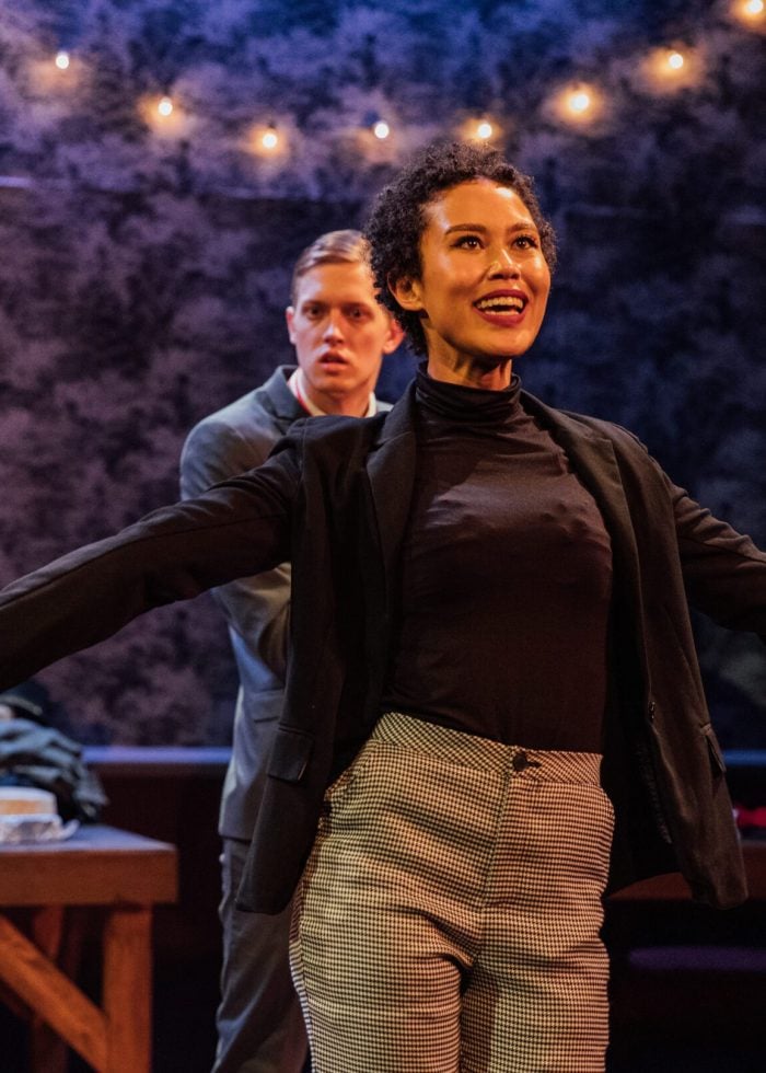 a woman with her arms out and a man in the background