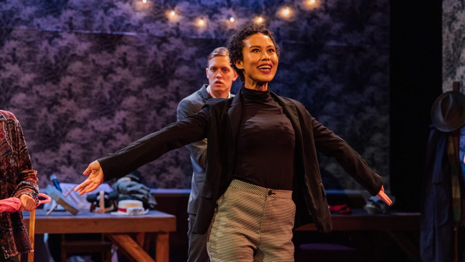 a woman with her arms out and a man in the background