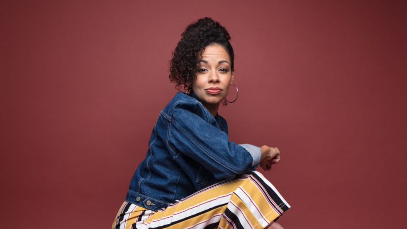 Latina actress in denim jacket and striped pants, embodying the journey back to the stage.